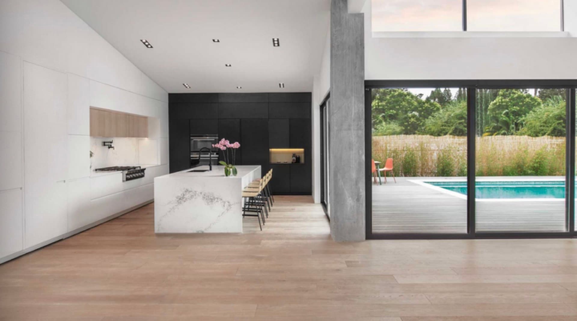 Custom kitchen in the Tice Valley area of Walnut Creek with a waterfall stone island, black full-height cabinetry, and professional range