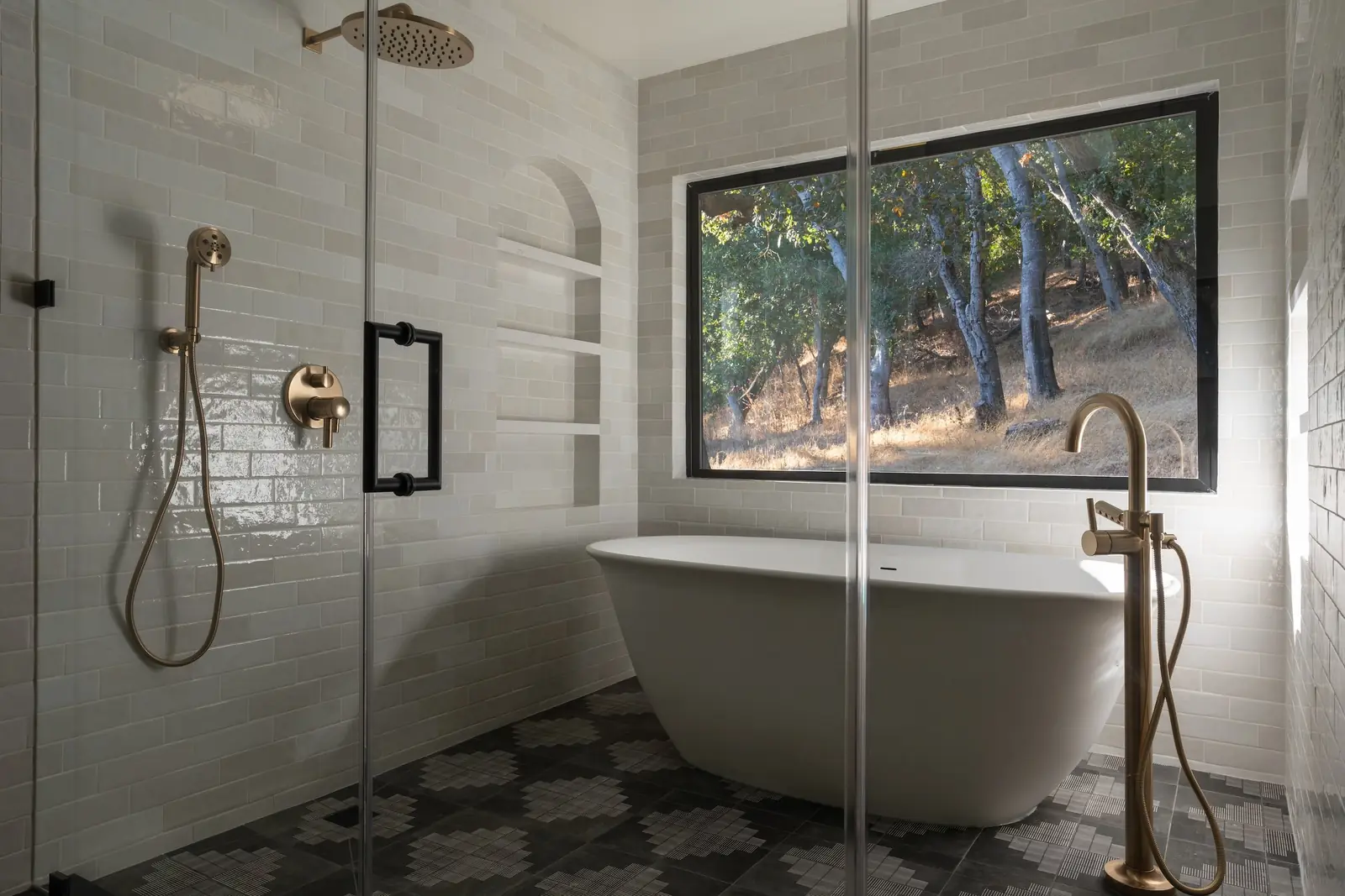 Finished primary bathroom renovation with a freestanding tub, glass walk-in shower and brass fixtures, built by a contractor in the Renovation Bridge network.