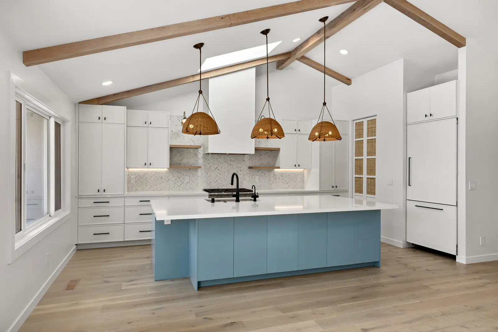 Finished kitchen renovation in Redwood City with a blue island, exposed ceiling beams and woven pendant lights, built by a network contractor.