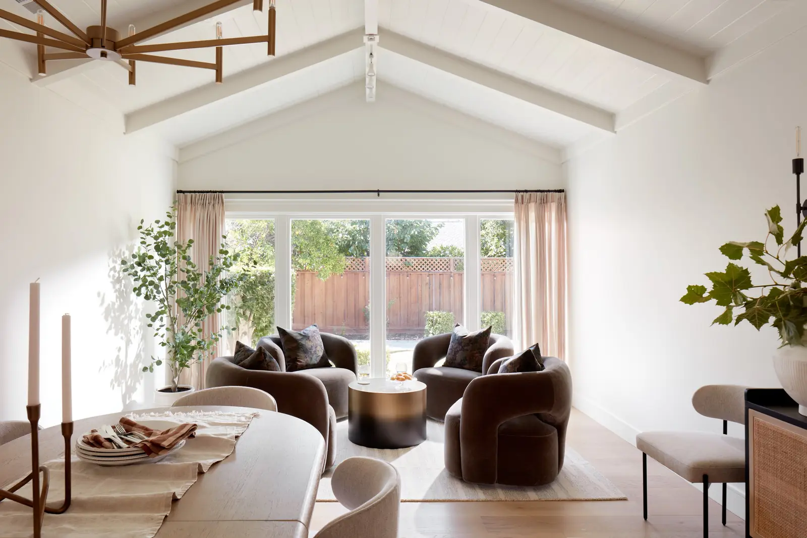 Finished living and dining room in a San Jose whole-home renovation, with a vaulted beamed ceiling and a wide bank of windows onto the garden, built by a network contractor.