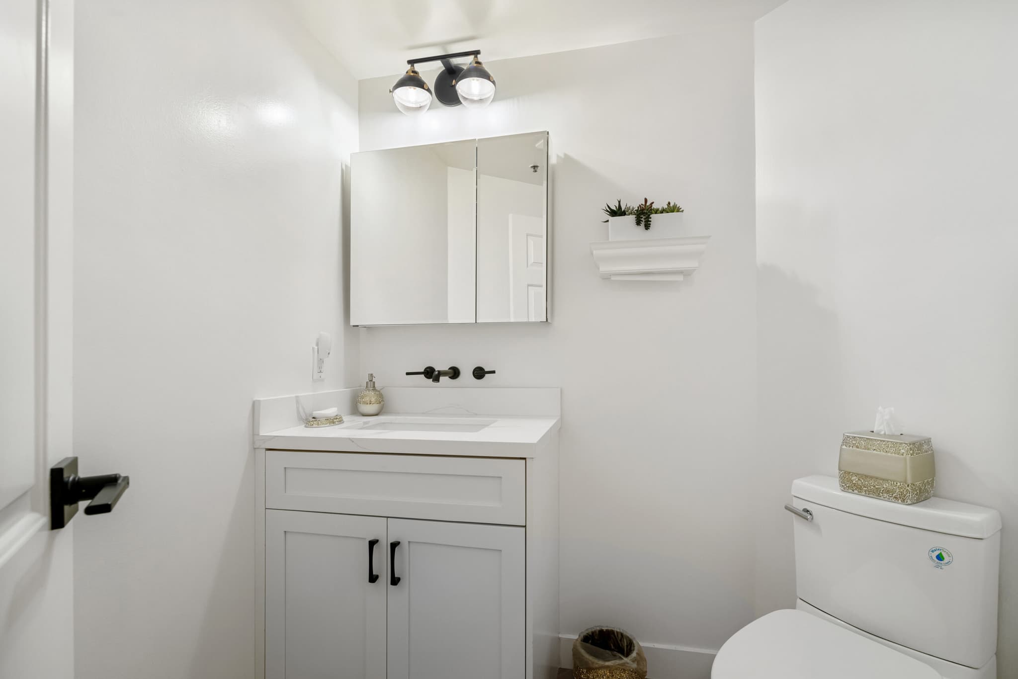 Renovated half bathroom with custom vanity and designer lighting
