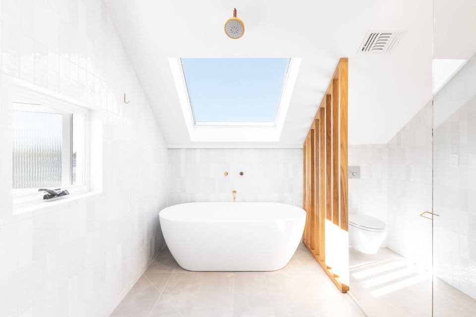 Remodeled bathroom with glass shower enclosure and modern tilework