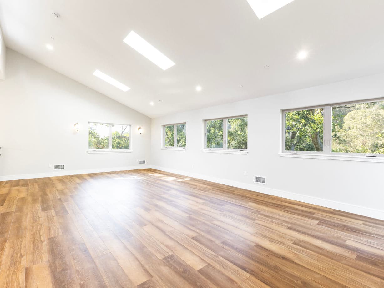 Renovated living area opening to a new kitchen with pendant lighting