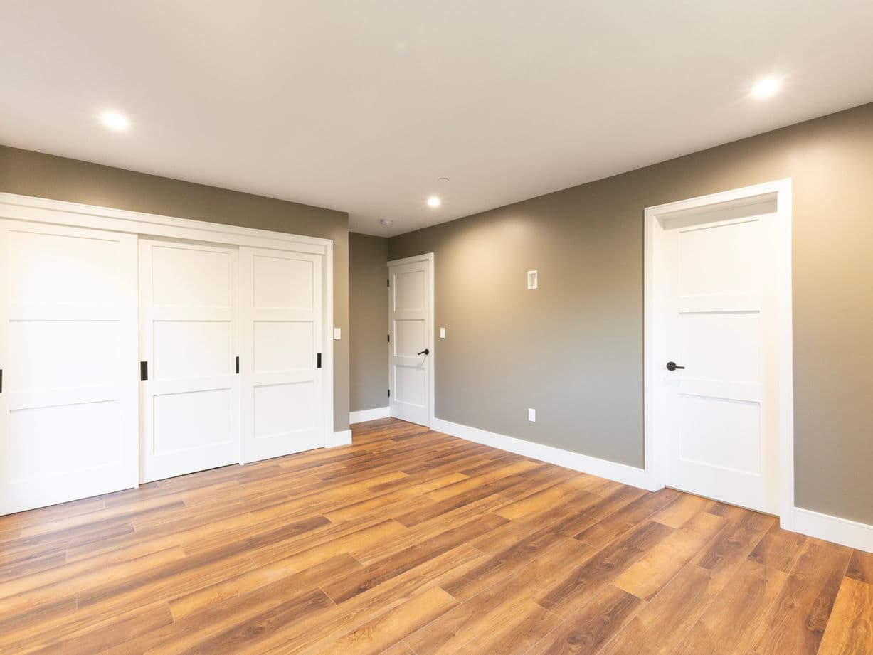 New bedroom with large windows and custom built-in storage